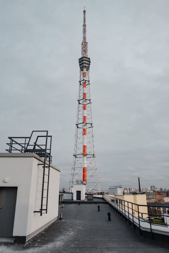 saint-petersburg-tv-tower-under-gloomy-sky-5066557 A towering telecommunication structure on a rooftop under a cloudy sky in an urban setting.