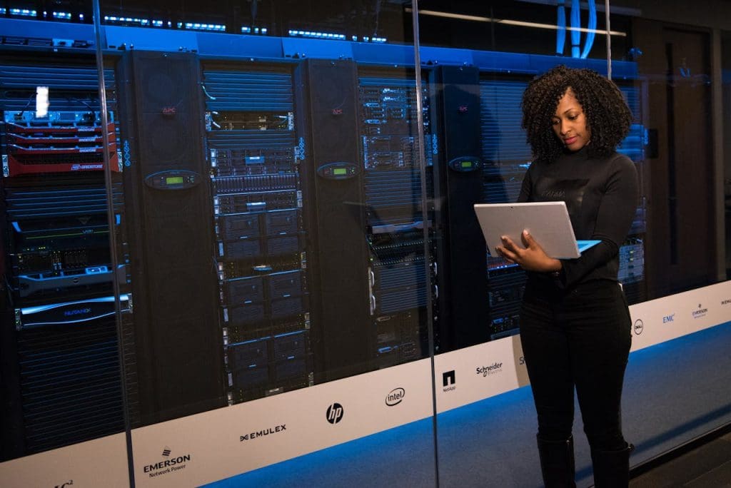 software-engineer-standing-beside-server-racks-1181354 A female engineer using a laptop while monitoring data servers in a modern server room.